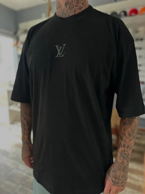 Camiseta preta com pequeno detalhe no peito em foto da loja
